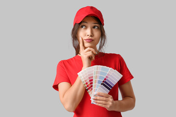 Poster - Thoughtful young woman with palette samples on grey background