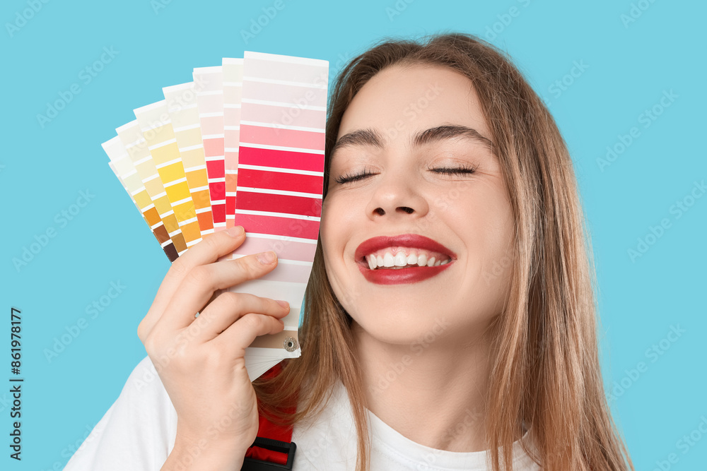 Female painter with color palettes on blue background, closeup
