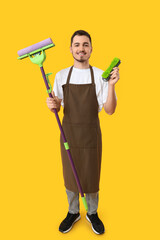 Poster - Male janitor with floor mop and brush on yellow background