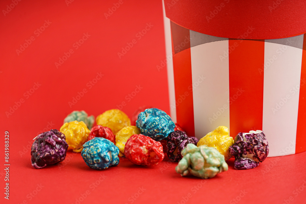Sweet colorful popcorn with bucket on red background