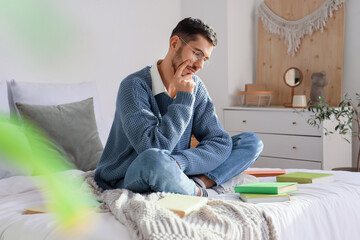 Sticker - Thoughtful young man with books in bedroom