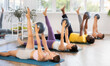 © JackF - Group of multiethnic men and women doing pilates with soft ball on mat in fitness studio