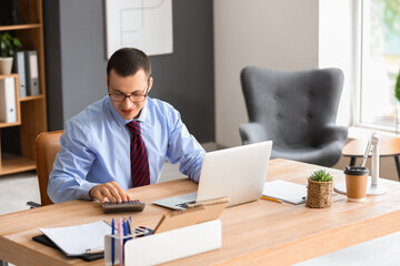 Poster - Male accountant working with calculator at table in office