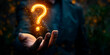 © Gabriela - A hand holding a glowing question mark. Concept of curiosity and wonder, as the question mark is lit up and he is floating in the air