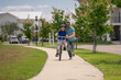 © Volodymyr - Little kid learning to ride bicycle with father on on summer holiday. Father teaching son cycling. Father and son learning to ride a bicycle at Fathers day. Father support and helping son. Child care.