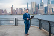 © Volodymyr - Mature hispanic businessman at the city. Businessman with laptop on streets of New York City's financial district. Businessman at Manhattan. Businessman works on laptop outdoor. Business in NYC.