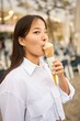 © alvaro - Asian woman enjoying ice cream outdoors