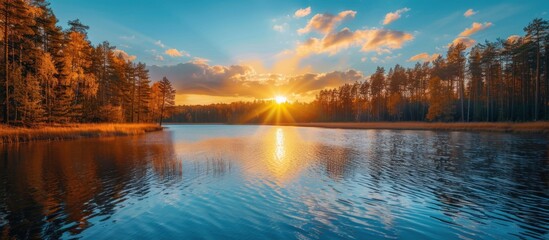 Wall Mural - Stunning sunset over calm lake with reflections in water, golden hour with colorful sky. Nature photography of tranquil lake and forest with trees on the shores.