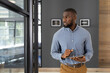 © Wavebreak Media - Using tablet, African American male professional standing in modern office environment