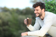 © Antonioguillem - Happy man in a terrace drinking coffee looking away