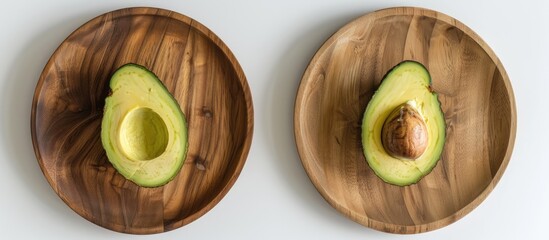 Poster - A bird's eye view of a halved avocado with and without the seed on a round wooden plate against a white background in a kitchen, promoting health benefits with a copy space image.