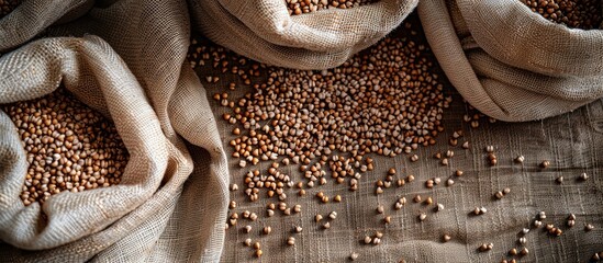 Close-up of buckwheat on textured fabric, surrounded by full bags, ideal for a copy space image showcasing this healthy natural organic grain.