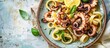 © HN Works - Top view copy space image featuring homemade octopus pasta with lemon and herbs, a Mediterranean dish set against a sunny summer tile background.