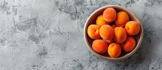 Wall Mural - Delicious ripe apricots arranged in a bowl with a light background and space for text or images. Copy space image. Place for adding text and design