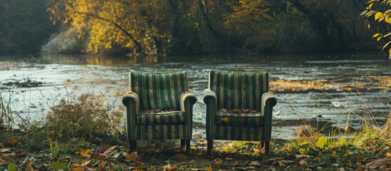 Sticker - A pair of striped outdoor chairs in green and grey set amidst a meadow by the riverbank, with a blank space for an image; focused view. Copy space image. Place for adding text and design