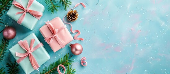 Poster - Top view of Christmas-themed arrangement with pink presents on a blue backdrop, offering ample copy space image.