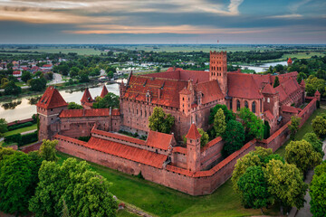 Sticker - Castle of theTeutonic Order in Malbork by the Nogat river at sunset.