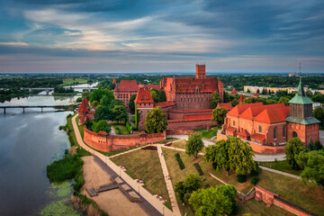 Wall Mural - Castle of theTeutonic Order in Malbork by the Nogat river at sunset.