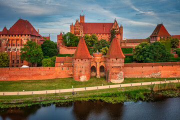 Wall Mural - Castle of theTeutonic Order in Malbork by the Nogat river at sunset.