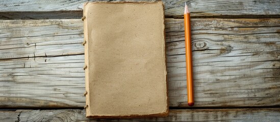Leinwandbilder - A brown notebook and pencil placed on a wooden desk, creating a serene copy space image.