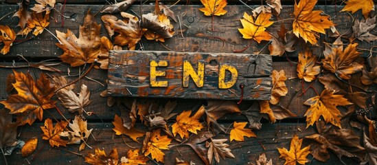 Wall Mural - Autumn leaves in yellow hue with the word END on a wooden backdrop, suitable for copy space image.