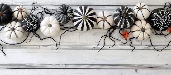 Poster - A Halloween-themed frame featuring black and white patterned pumpkins and spider web decorations arranged on a white wooden background, providing ample copy space image.