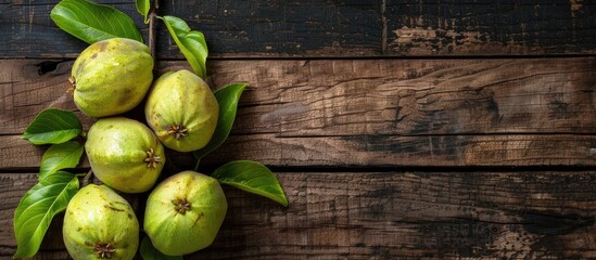Wall Mural - Top view of ripe green guavas displayed on a rustic wooden surface with copy space image.