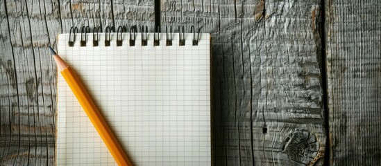 Fototapete - Image of a notepad and pencil on a wooden background, suitable for educational or business purposes, emphasizing the space for text or objects in photography. Copy space image
