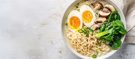 Poster - Top-down view of a white bowl containing ramen noodle soup with eggs, mushrooms, and pak choi on a light background, offering ample copy space for an image.