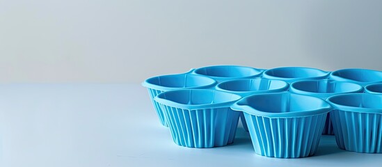 Poster - Silicone cupcake mold in blue against a white backdrop with copy space image.