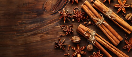 Poster - Wooden table adorned with aromatic cinnamon sticks and anise stars in a flat lay arrangement with available copy space image.