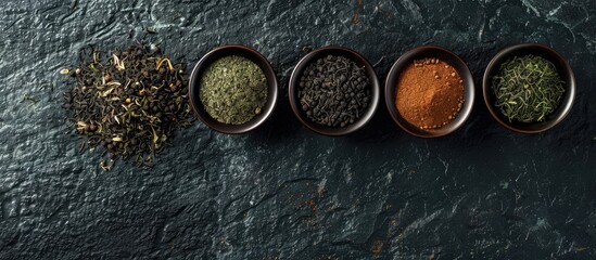 Aufkleber - Four bowls showcasing a variety of tea types, including black and green, set against a textured black stone backdrop with copy space image available.