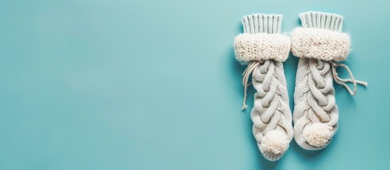 Poster - Flat lay winter clothes item - soft knitted socks on a light blue background, perfect for a copy space image.