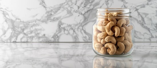 Aufkleber - Cashew nuts displayed in a clear glass jar on a marble countertop with ample copy space image.