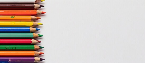 Poster - Colorful pencils set against a white backdrop providing ample copy space image.