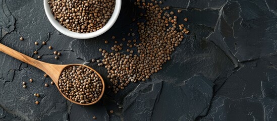 Aufkleber - Flat lay with beluga lentils in a round white bowl, a wooden spoon, on a black backdrop, along with a copy space image.