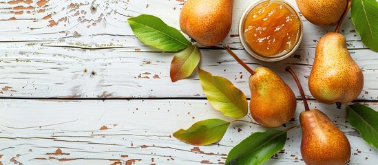 Poster - Golden homemade pear jam with farm-fresh pears and leaves on a white wooden backdrop for a versatile copy space image.