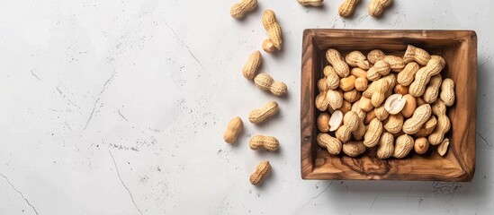 Aufkleber - A wooden tray filled with peanuts in shells on a white background, with blank space on the right for text or images; ideal for copy space image.