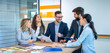 © Bojan - Entrepreneurs engaging in business discussions, collaboratively seeking solutions. Group of professionals converses while gathered at office desk.