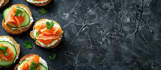 Poster - Top view of delicious salmon, cream cheese, and cucumber toasts on a black table with ample copy space image.