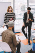 © BullRun - Portrait of successful female coach conducting training design session for creative multicultural students in stylish coworking space.Diversity group of young designers teamworking on common project