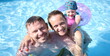 © H_Ko - Family portrait of smiling parents and child in pool. Family swimming for kids and adults concept