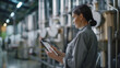 © Maksym - A woman with a tablet stands in a modern tea processing plant, reviewing data on drying and packaging, close-up