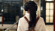 © Meeko Media - Back View of Woman with Headphones in Modern Industrial Office Space