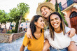 © Davide Angelini - Three multiethnic girls having fun walking in city street - Happy young women laughing together enjoying summertime vacation
