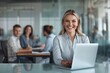 © Surachetsh - Confident businesswoman with a professional posture, smiling warmly as she sits on a modern office chair, ready to collaborate with her team.