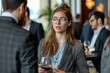 © alphaspirit - Businesswoman is discussing with a colleague during a networking event, holding a glass of wine