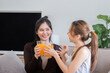 © Natee Meepian - Lesbian Couple Enjoying Healthy Orange Juice Together in Modern Home Setting