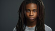 © ALA - Portrait of a serious, troubled African-American teenage guy with long hair and perfect skin, gray background, banner.