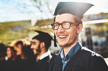 Wall Mural - Man, portrait and smile for university graduation with glasses, happiness for degree or diploma event. People, graduate class or education achievement at college campus, pride for goal with knowledge